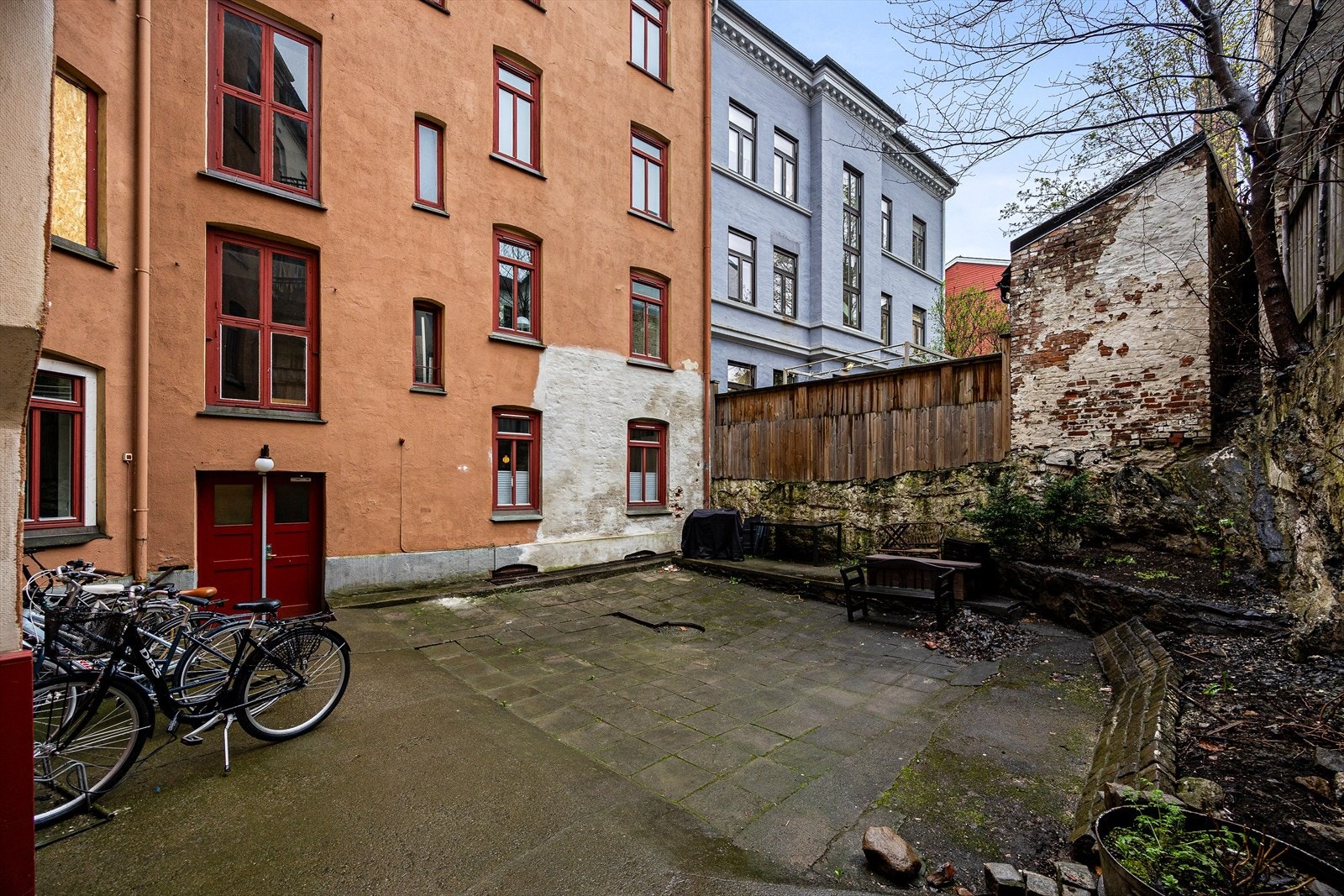 Bakgården er asfaltert og hellebelagt og er beplantet med bed og potter Galleribilde