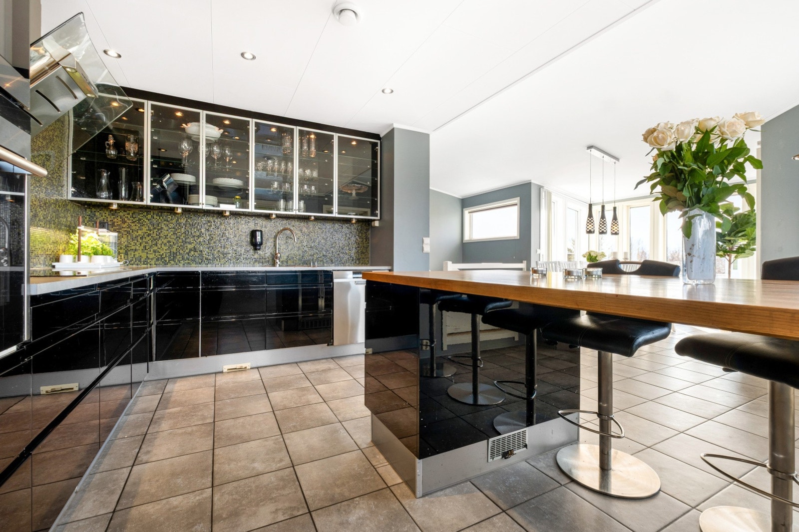 Benkeplaten gir rikelig med arbeidsplass, og en mosaikkflisvegg i grønt og gull tilfører et stilig preg. Galleribilde