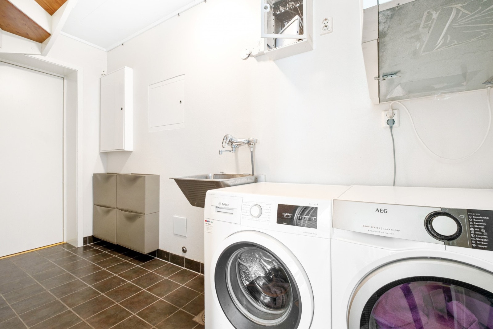 Praktisk vaskerom med opplegg for vaskemaskin. Galleribilde