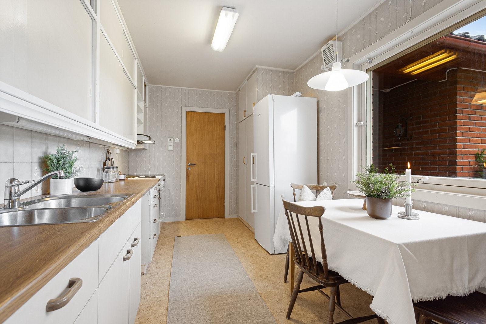 Kjøkken med plass til hyggelig spisegruppe. Innredningen har glatte fronter og benkeplate i laminat. Frittstående hvitevarer. Galleribilde