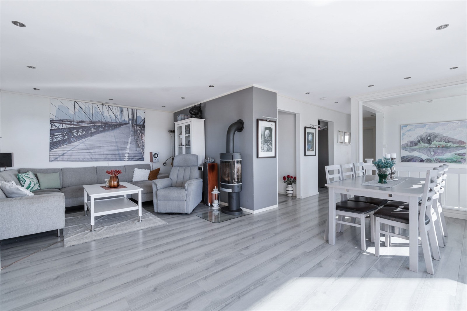 Stuen er både romslig og innbydende, med en nyere peisovn som gir både varme og koselig stemning. Med en gulvflate på ca. 30 kvm gir rommet god plass til store, komfortable sittegrupper, perfekt for både avslapning og sosialt samvær. Galleribilde