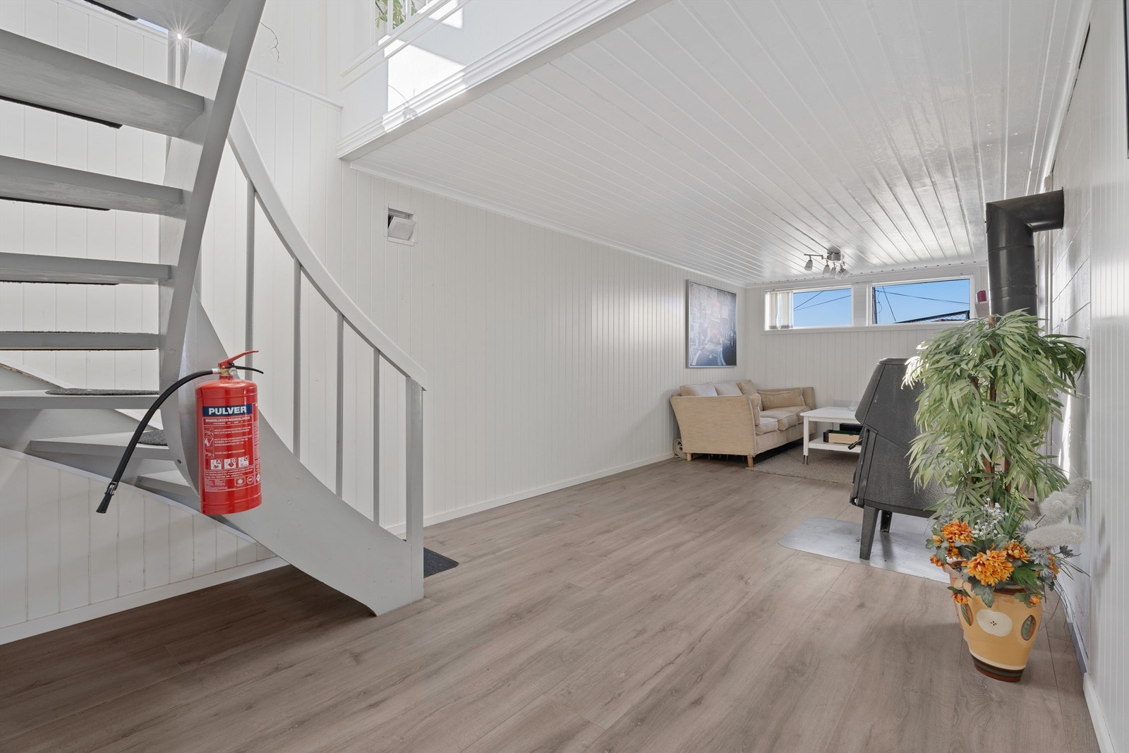 Den lyse og romslige kjellerstuen byr på en koselig atmosfære med peis som skaper varme og stemning. Her er det god plass til både stuemøbler og avslapning, et perfekt rom for hygge og samvær med familien eller venner. Galleribilde