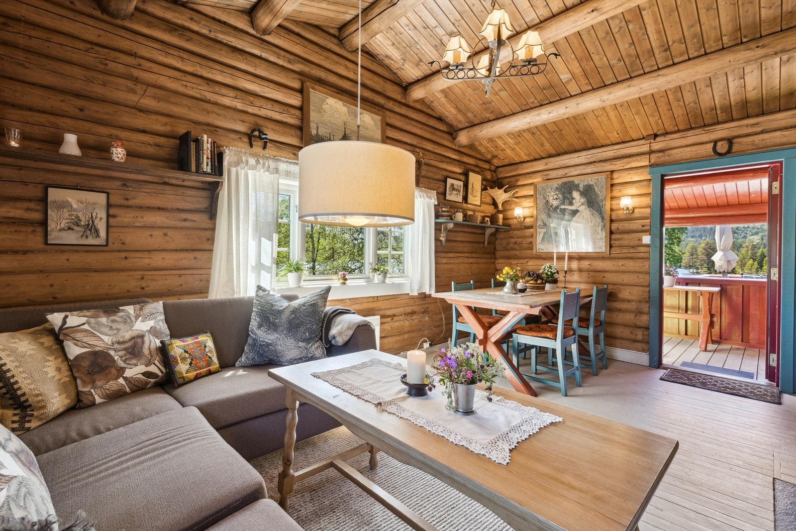 Stuen har en lun atmosfære med originale tømmervegger og høyt under taket. Galleribilde