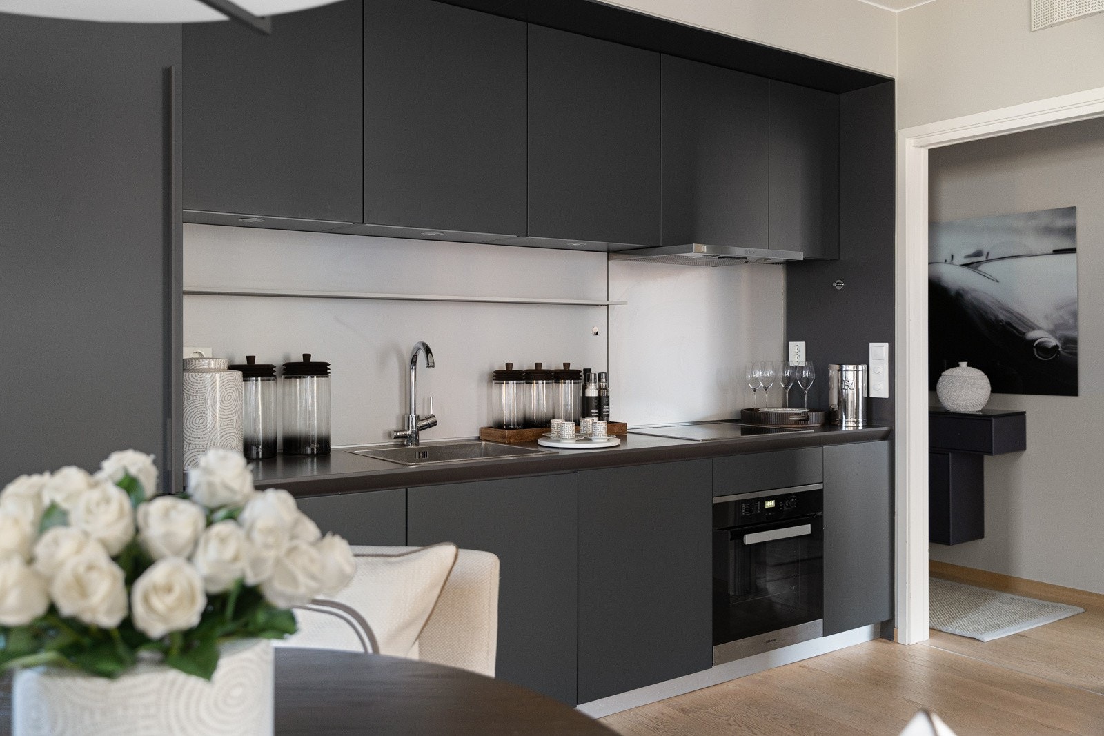 Kjøkkenet er innredet med integrerte hvitevarer fra Miele som komfyr, induksjonstopp, oppvaskmaskin og kjøl-/ fryseskap. Galleribilde