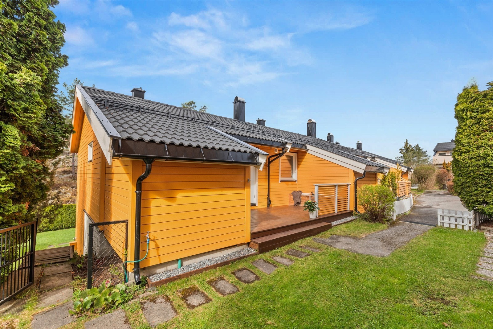 Terrassen foran har også en herlig formiddagssol. Herfra går det også trapp ned til hagen som boligen disponerer. Galleribilde