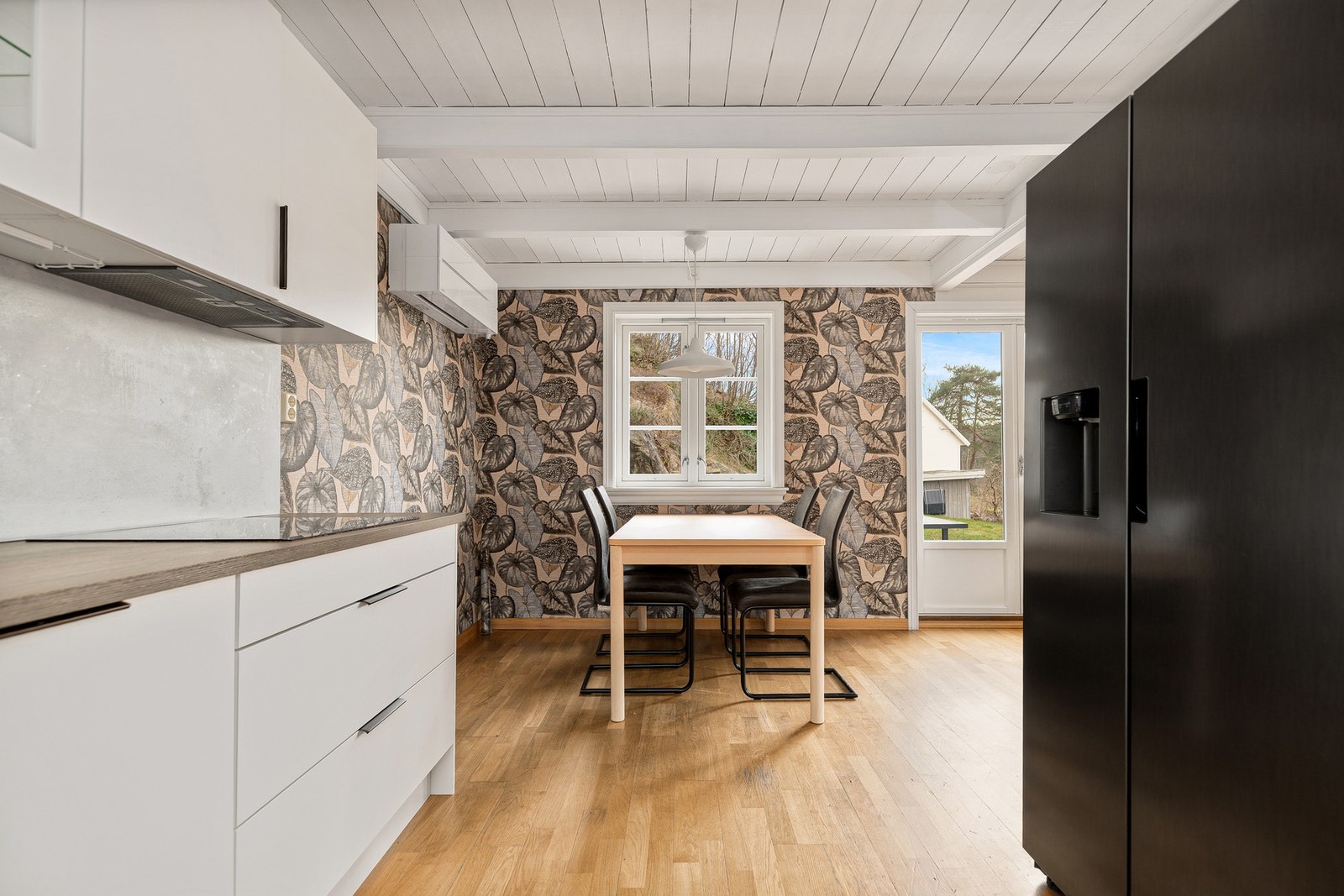 Kjøkken har parkett på gulv og veggene er med plater som er tapetsert. Galleribilde