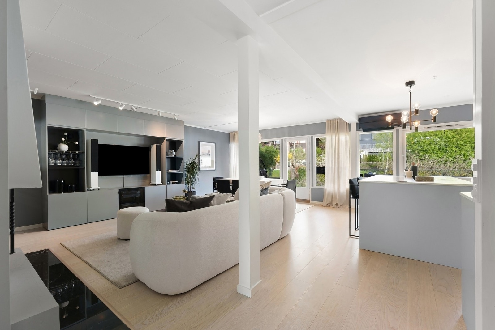 Lys og innbydende stue med åpen løsning mot kjøkkenet. Store vindusflater slipper inn rikelig med dagslys og gir en luftig romfølelse Galleribilde