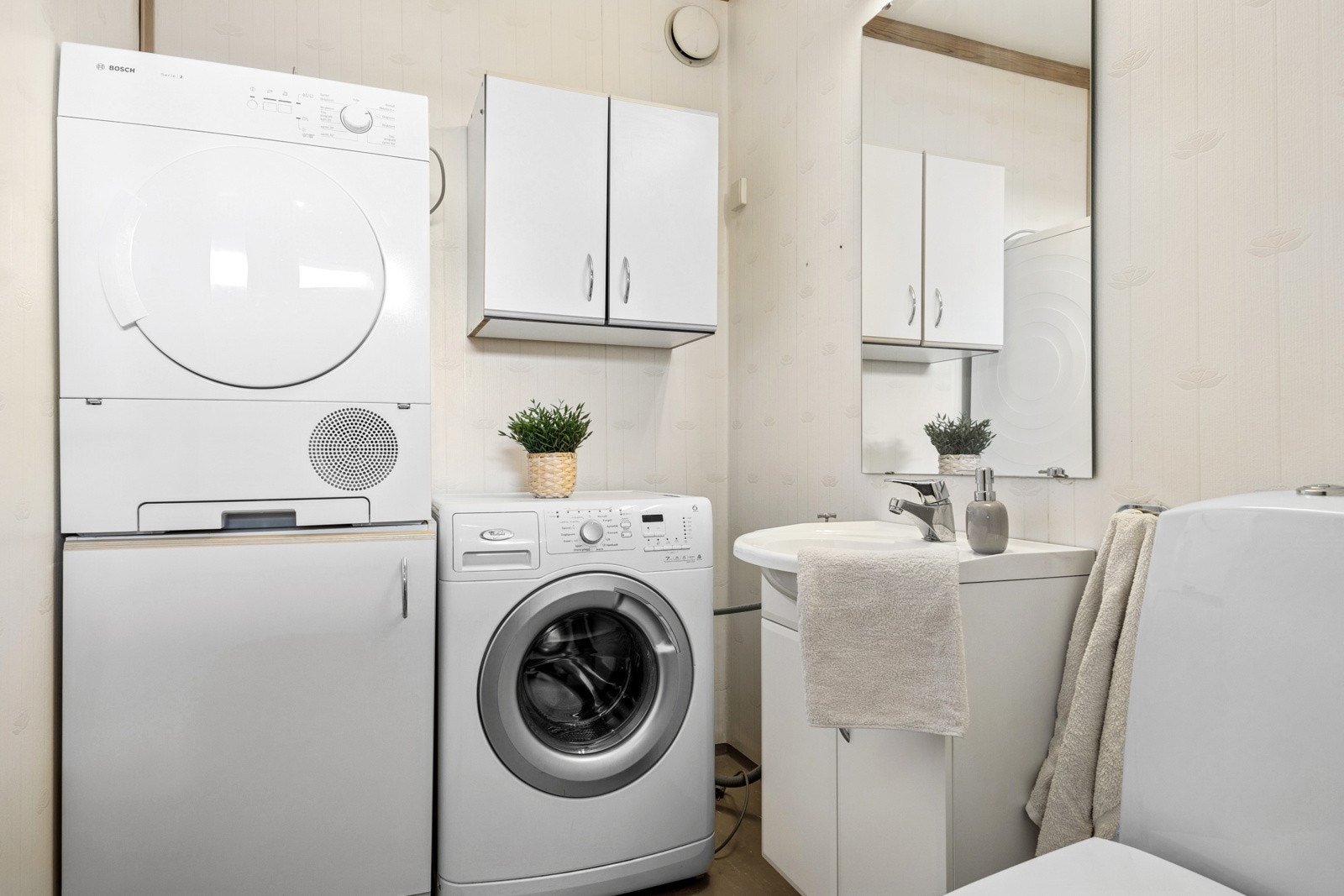 Vaskerommet er innredet med toalett, servant og flere skap til oppbevaring av baderomsartikler. Galleribilde