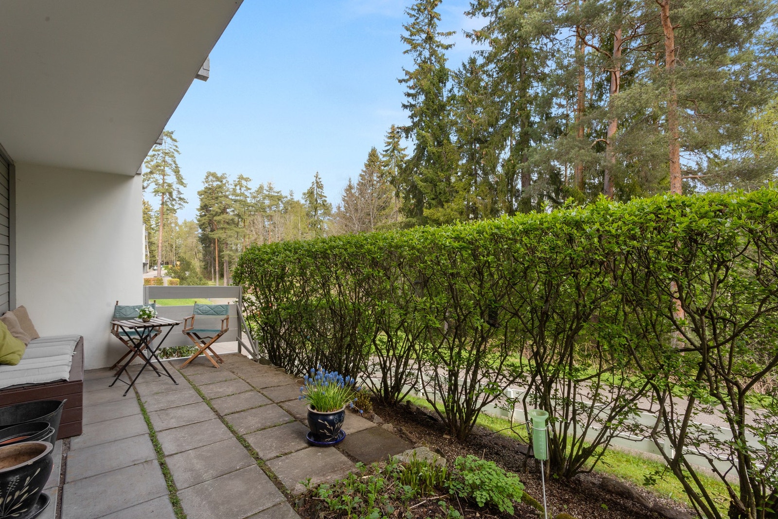 Utgang til en flott uteplass på ca. ca. 14,4 m² mot felles inngangsparti og et grønt skogholt. Galleribilde