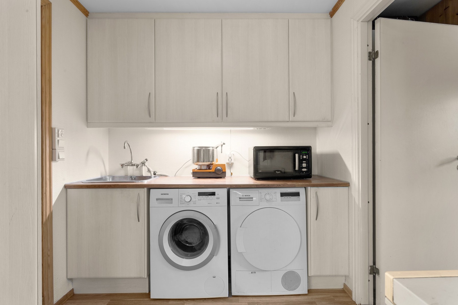 I enden av kjøkken er det avsatt en praktisk vaskenisje med kum, samt opplegg for vaskemaskin og tørketrommel. Galleribilde