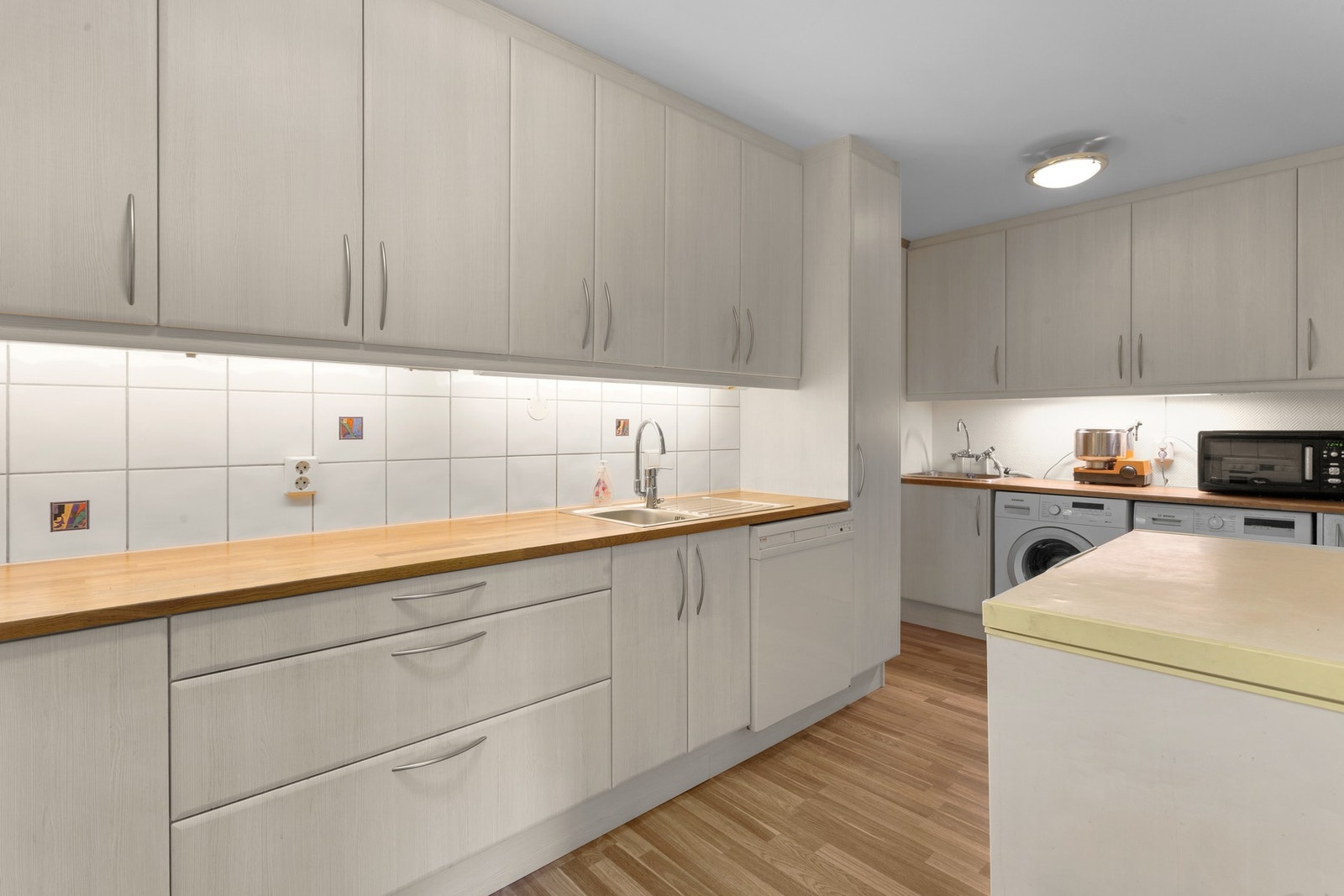 Kjøkkenets utforming på godt med skap- og benkeplass. Galleribilde