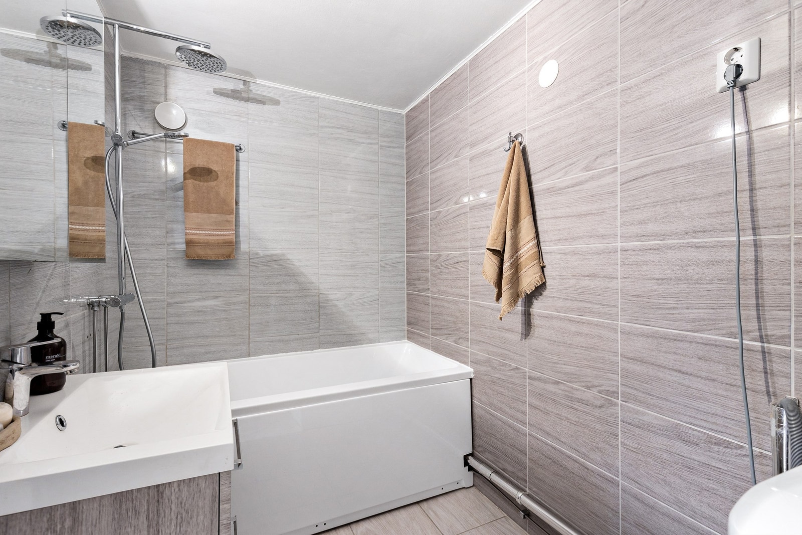 Badet er innredet med servant nedfelt i innredning, speilskap m/lys og badekar. Det er både plass og opplegg for vaskemaskin. Galleribilde
