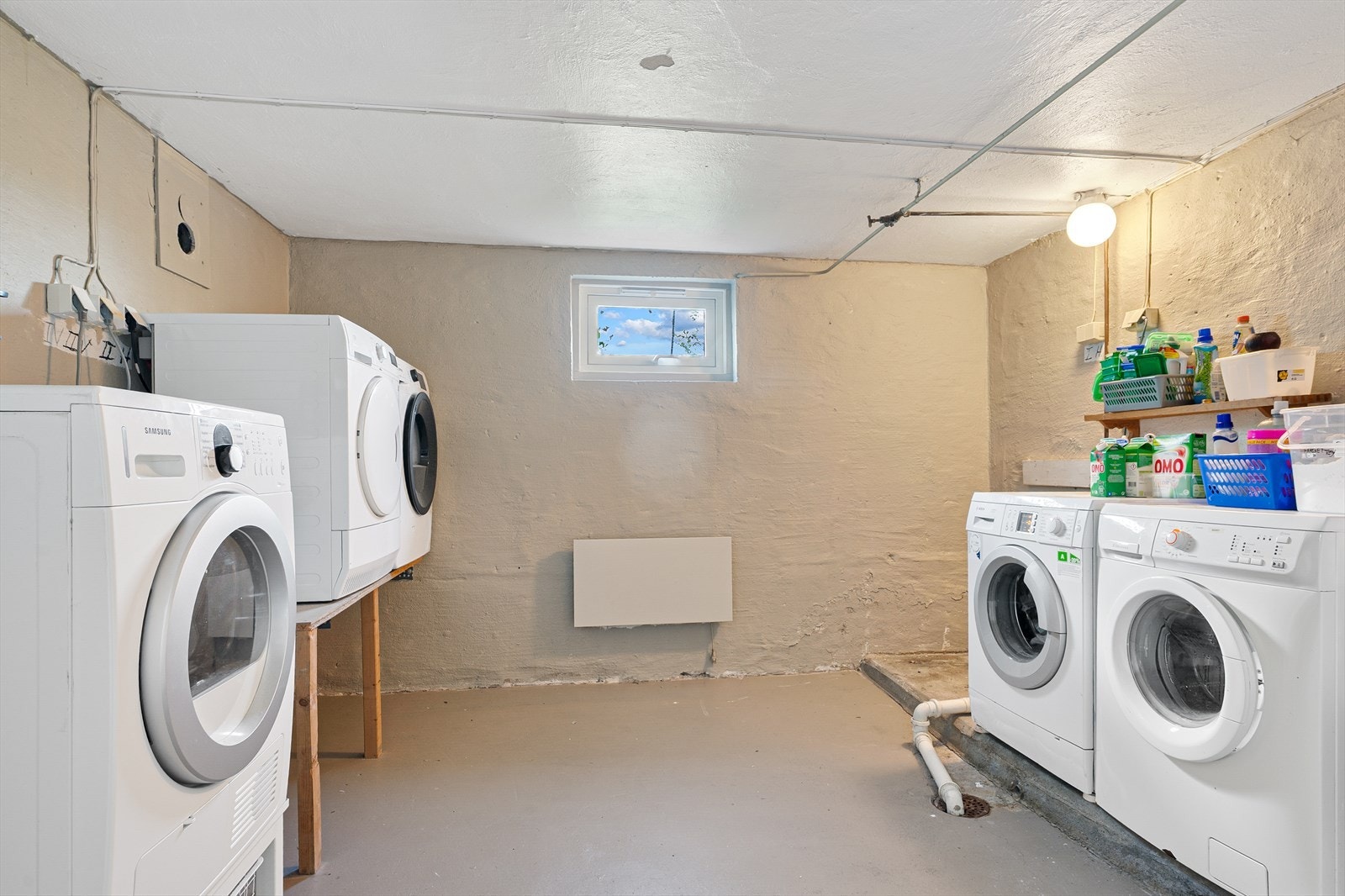 Felles vaskeri i kjeller hvor man har plass til både vaskemaskin og tørketrommel. Galleribilde