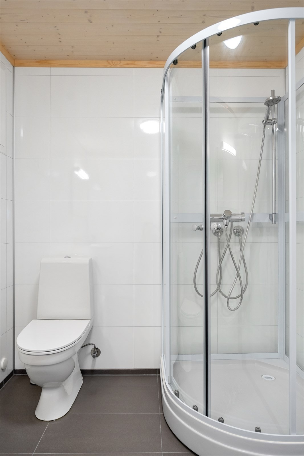 Inneholder gulvstående toalett, dusjkabinett, innredning m/servant, speil og rør-i-rør. Galleribilde