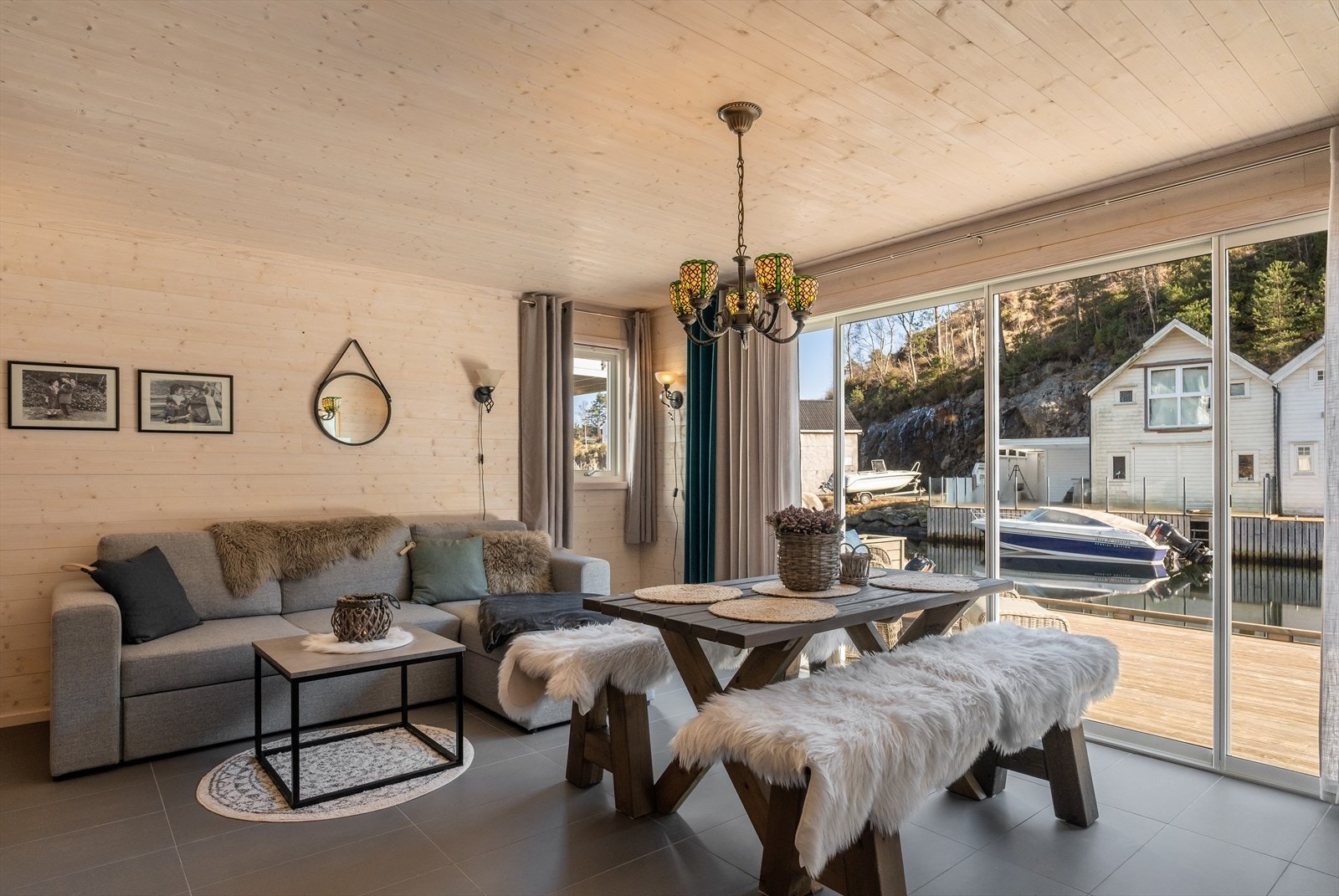 Flott innredet stue med skyvedører mot bryggen - Her får en følelsen av å sitte i maritime omgivelser fra sofaen. Galleribilde