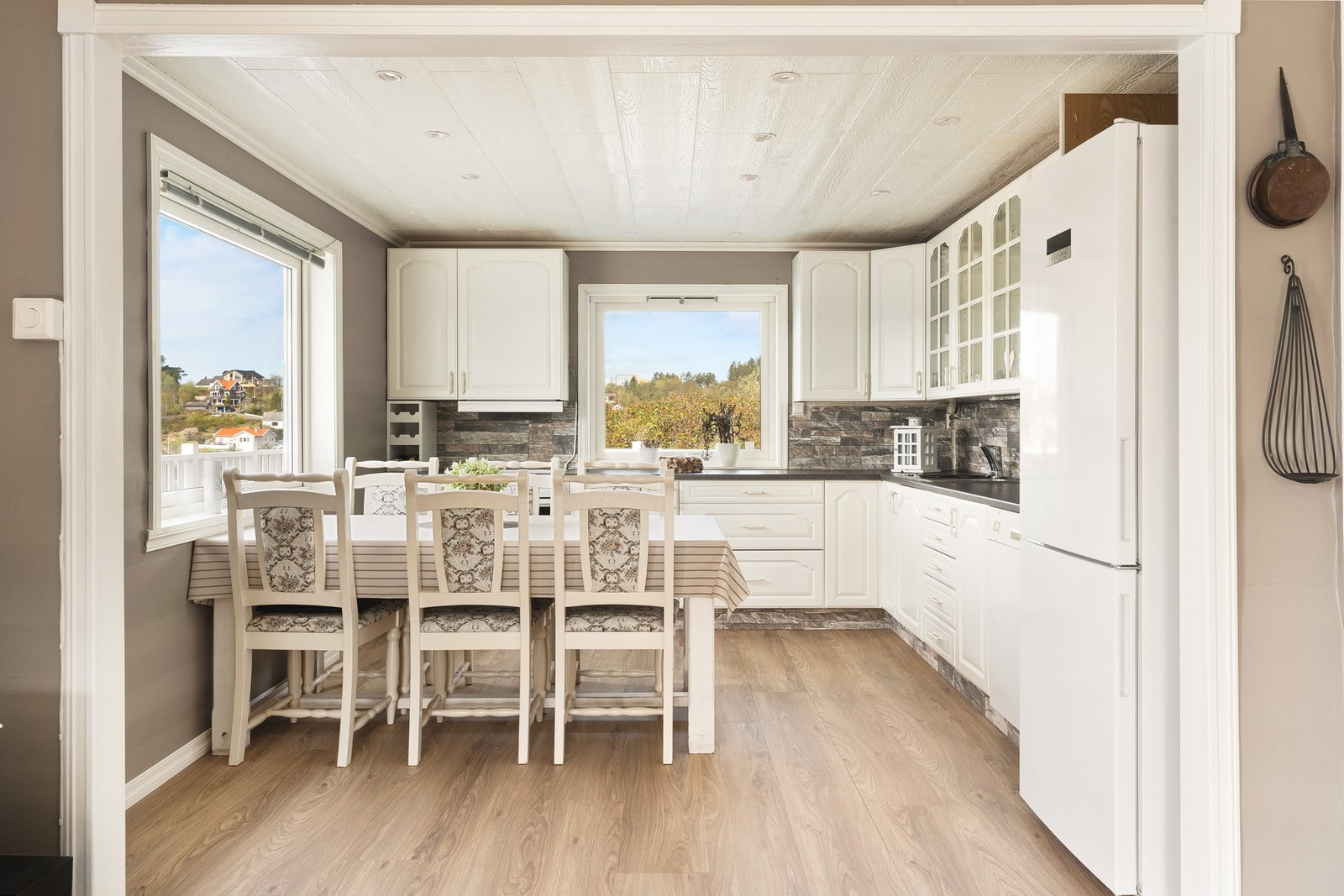 Kjøkkenet måler ca. 12 kvm og består av profilerte fronter, glasskap og laminat benkeplate med nedfelt vask av stål. Galleribilde