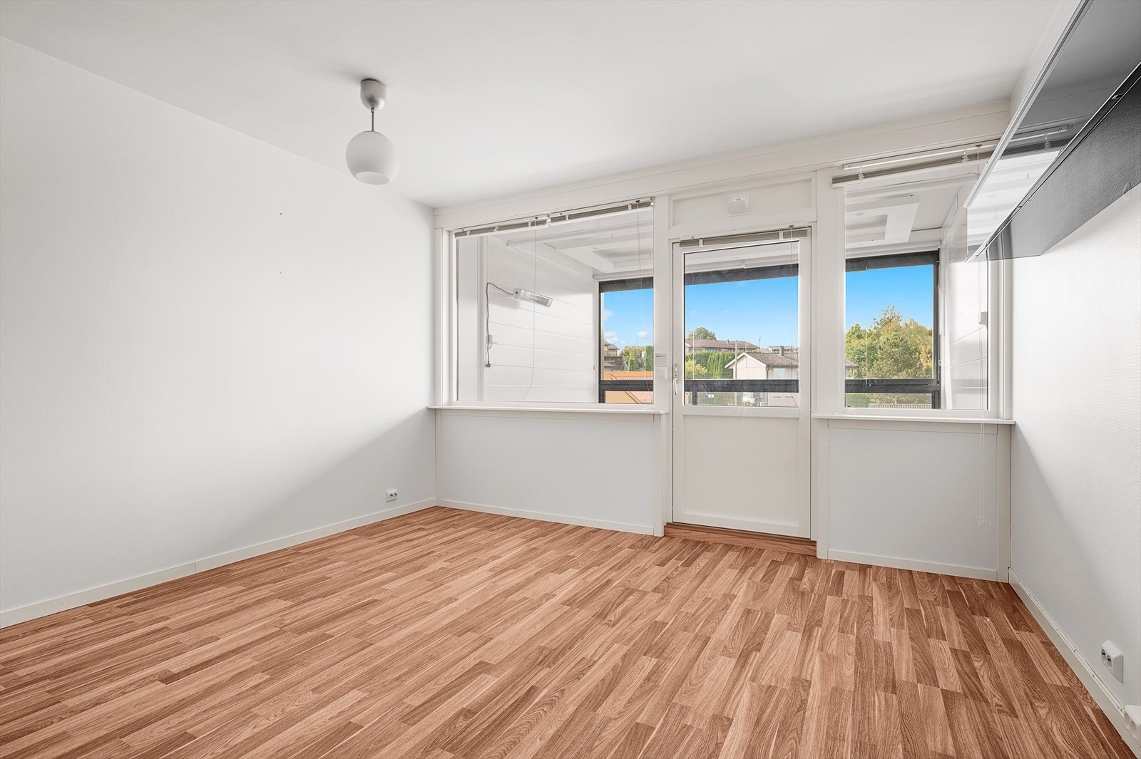 Stuen har lyse overflater, malt strie på veggene og 3-stavs laminat på gulvet Galleribilde