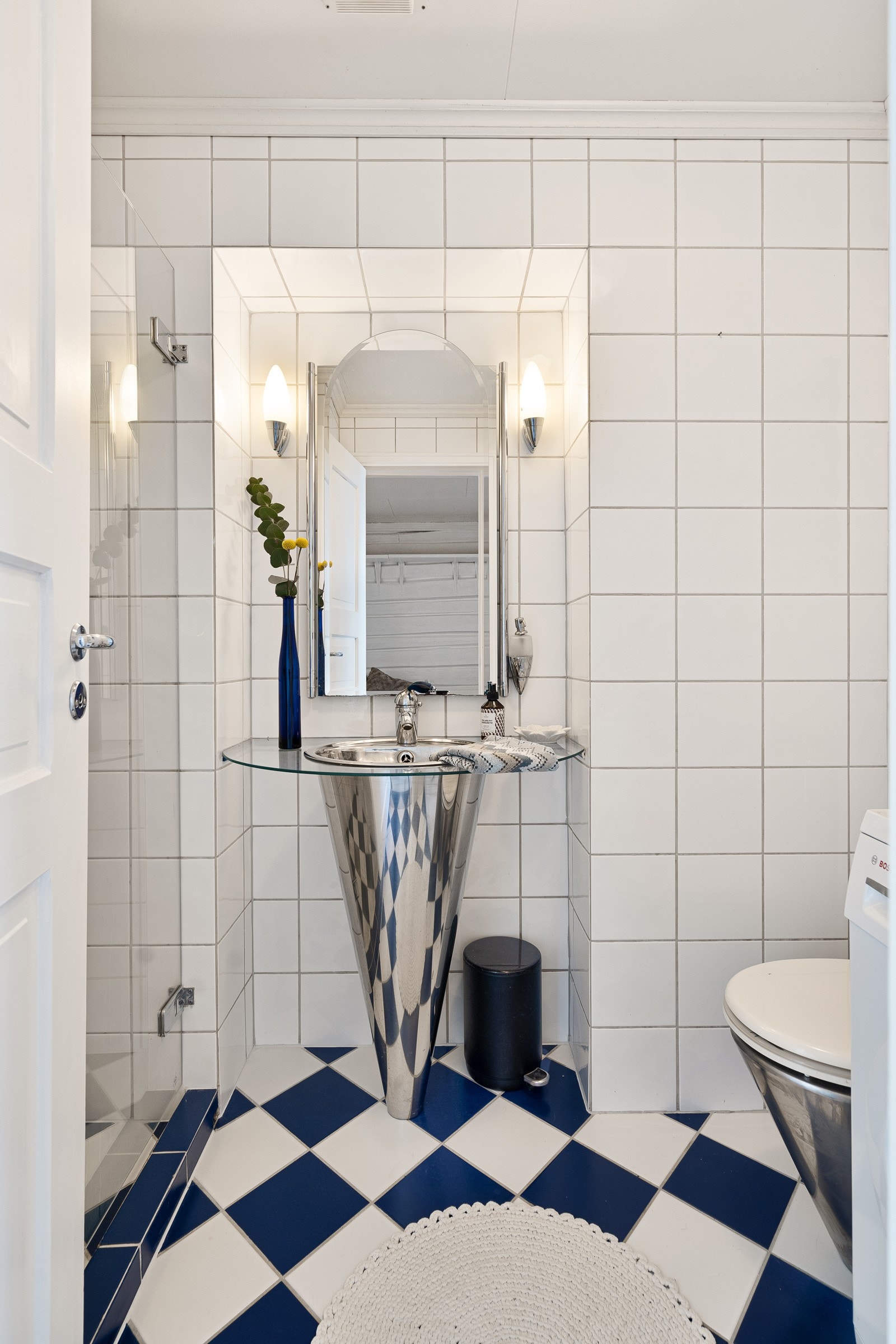 En søyleservant matcher toalettet, og er oppført i en nisje med speil og lampetter. Galleribilde