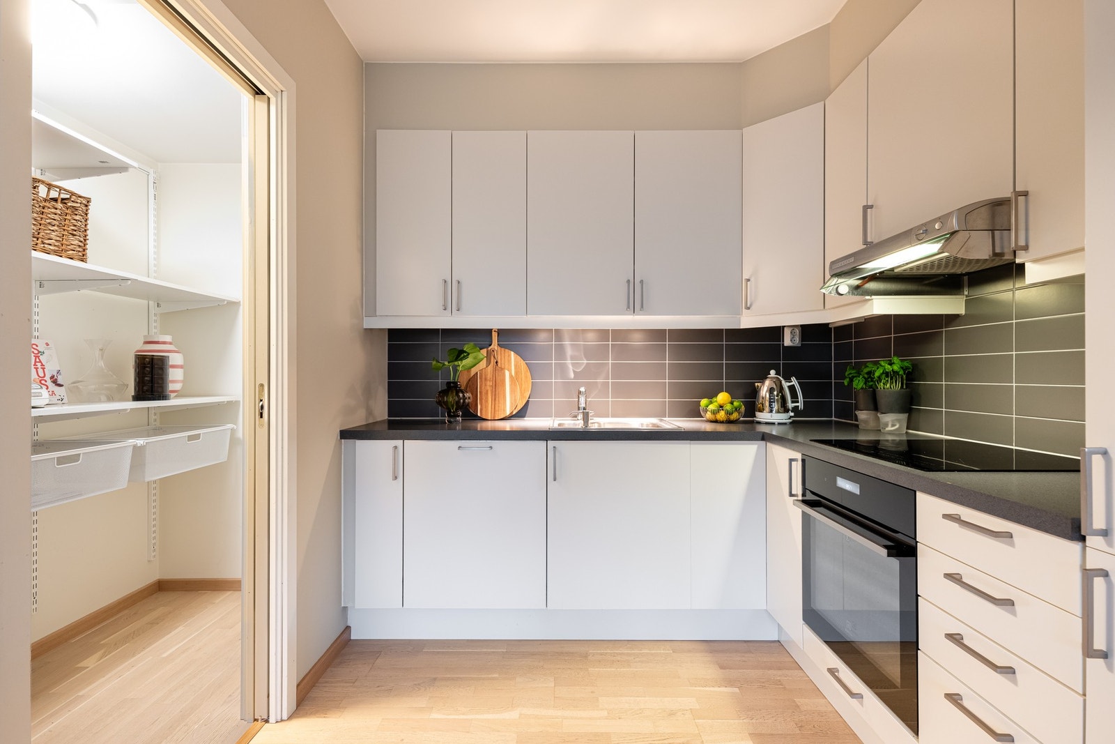 Lys Sigdal-kjøkkeninnredning med glatte fronter, laminat benkeplate og nedfelt oppvaskkum med ett-greps armatur. Galleribilde