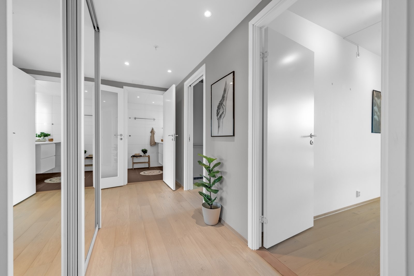 Leiligheten har en lys og innbydende entré, utstyrt med downlights i himlingen som skaper en varm og velkommende atmosfære - et perfekt førsteinntrykk. Galleribilde