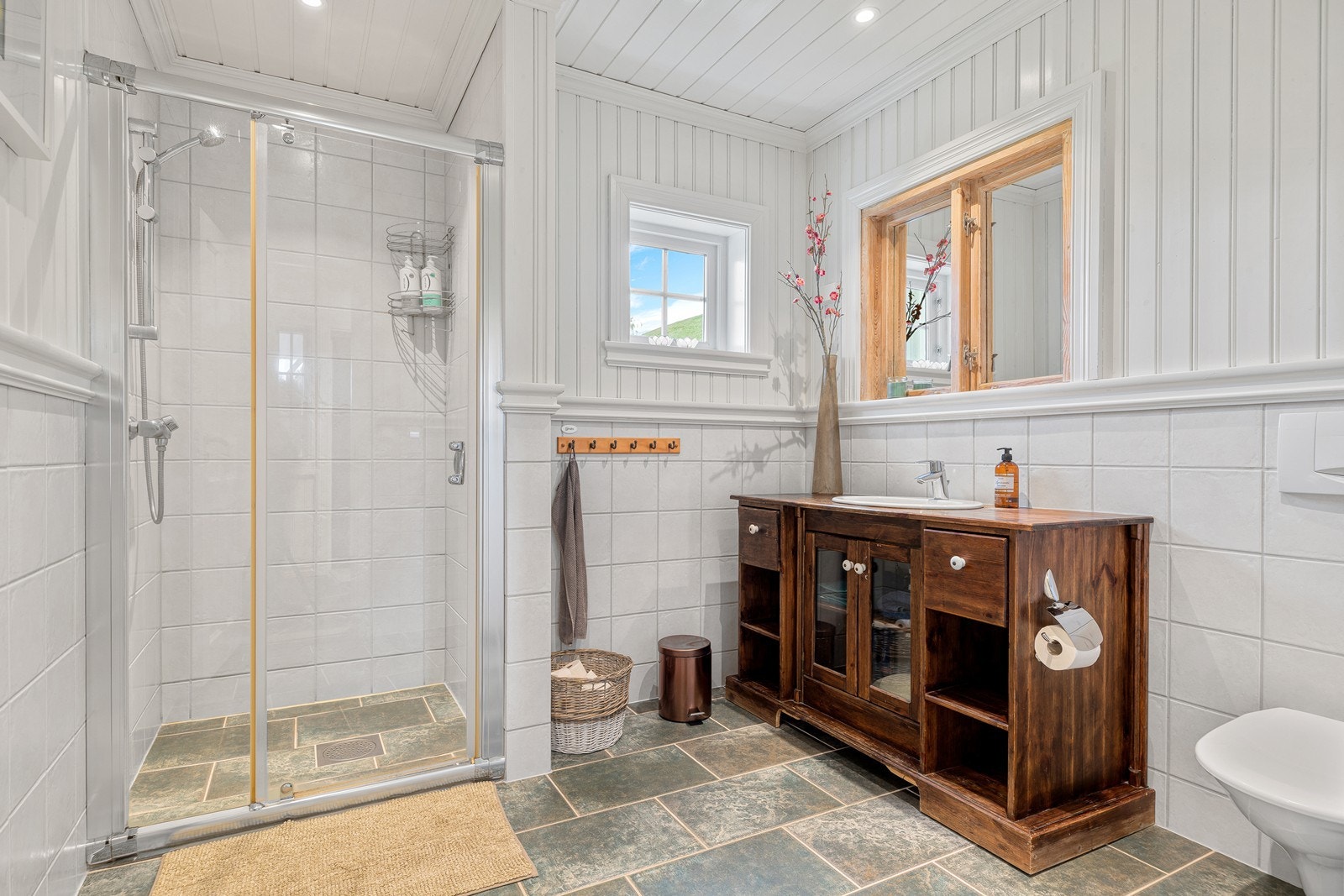 Boligens andre baderom består av dusjnisje med glassdør, baderomsmøblement og toalett. Galleribilde