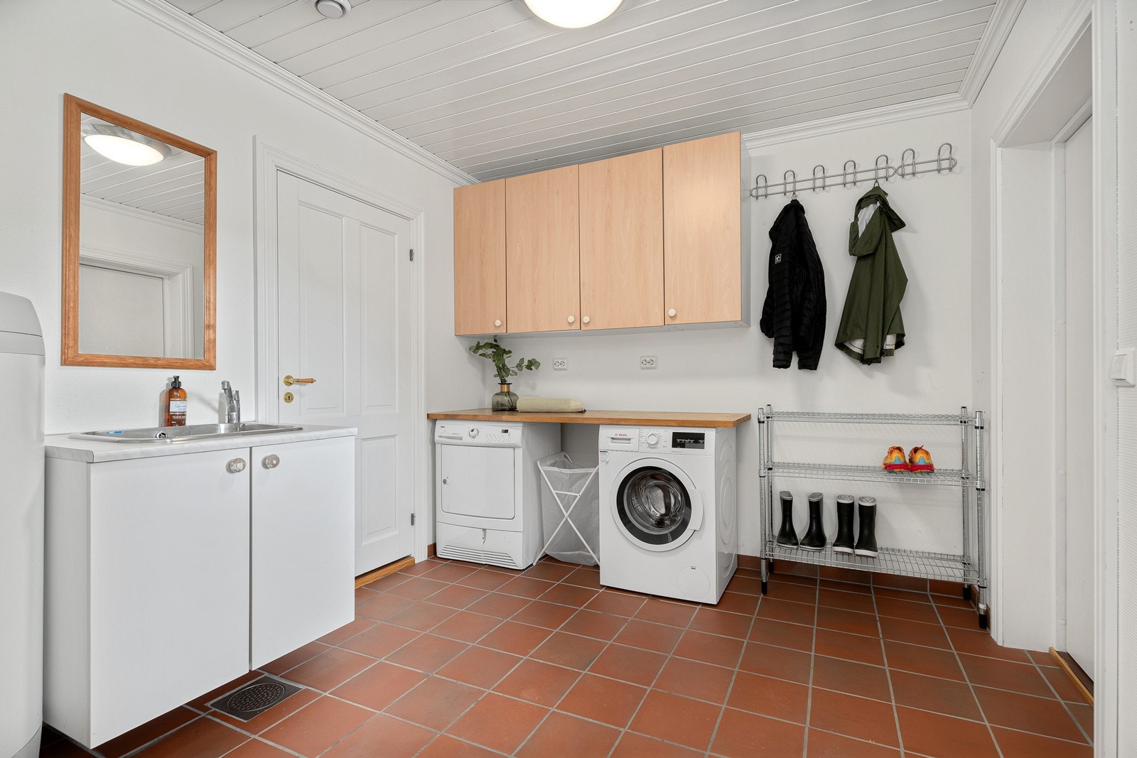 Praktisk vaskerom med god plass til oppbevaring i innredning. Galleribilde