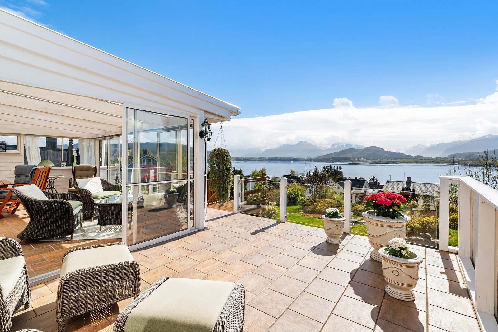 Terrassen og hagestuen har flislagt dekke, skyvedører og rekkverk med glassplater. Her kan du faktisk tilbringe ferien din. Galleribilde