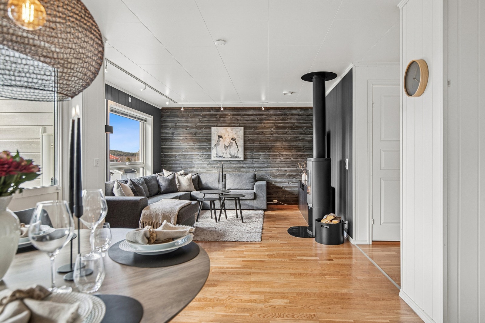 Lun og innbydende stue med flott peisovn og stilfull kontrastvegg. Store vindusflater gir godt med dagslys og en fin utsikt. Galleribilde