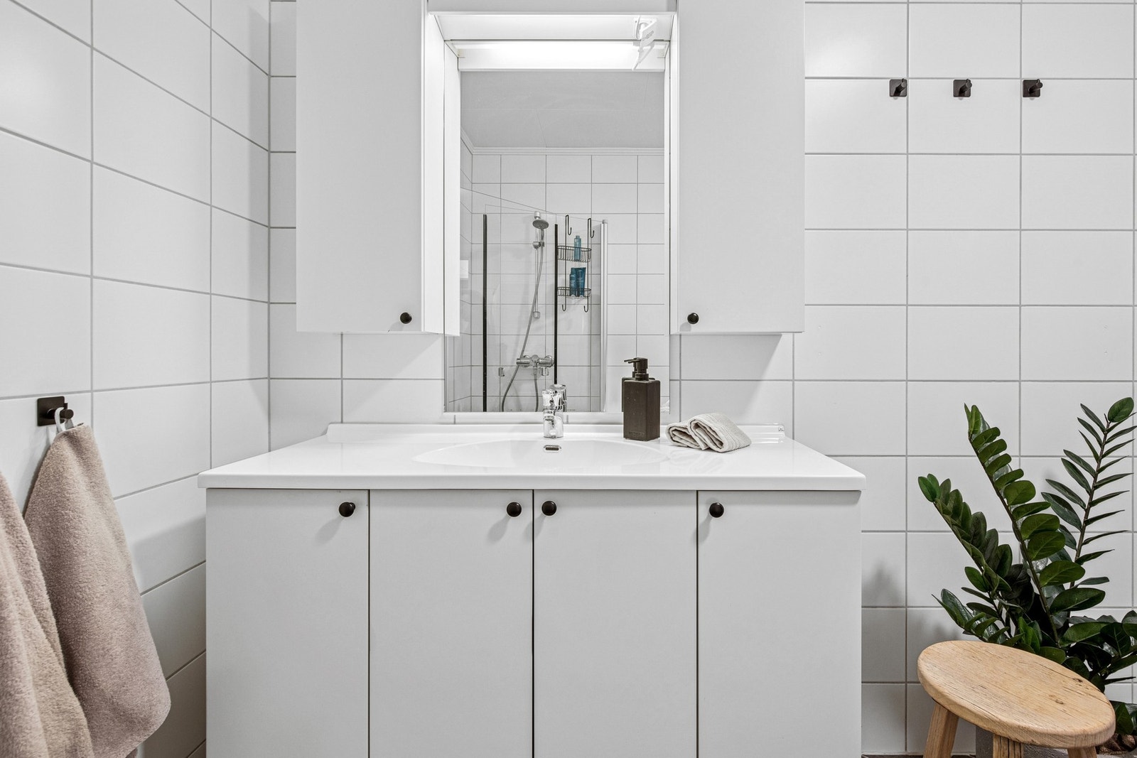 Badet har vegghengt servantskap, speil og overlys med stikkontakt som gjør badet til et funksjonelt rom i hverdagen. Galleribilde