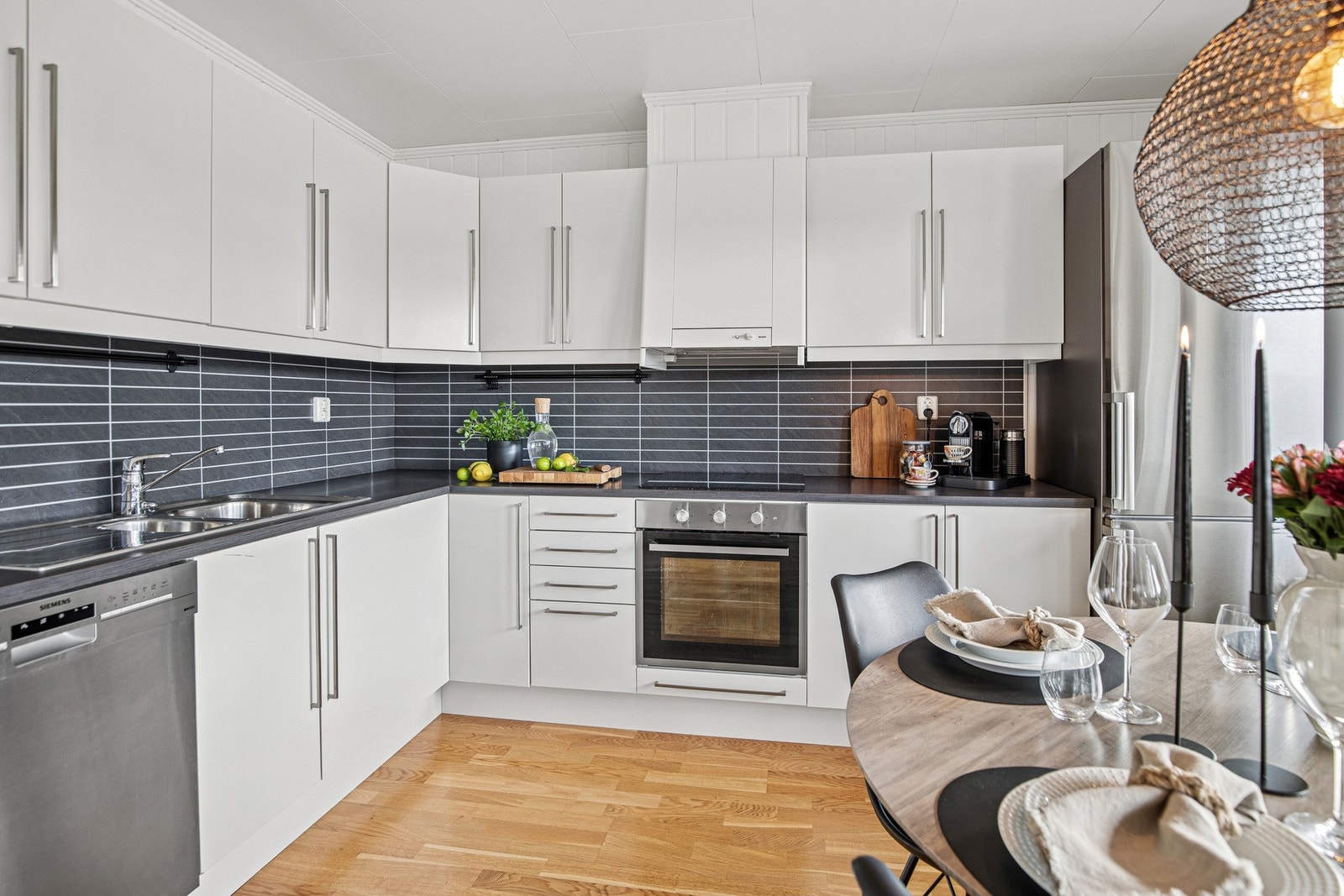 Kjøkkenet er lyst og moderne med god skapplass og stilrent design. Praktisk åpen løsning mot spiseplass. Galleribilde