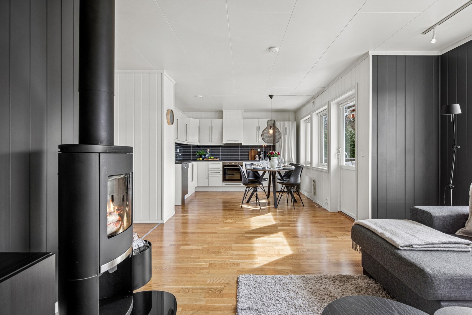 Lys og moderne stue med åpen kjøkkenløsning og store vindusflater som gir godt med naturlig lys. Galleribilde