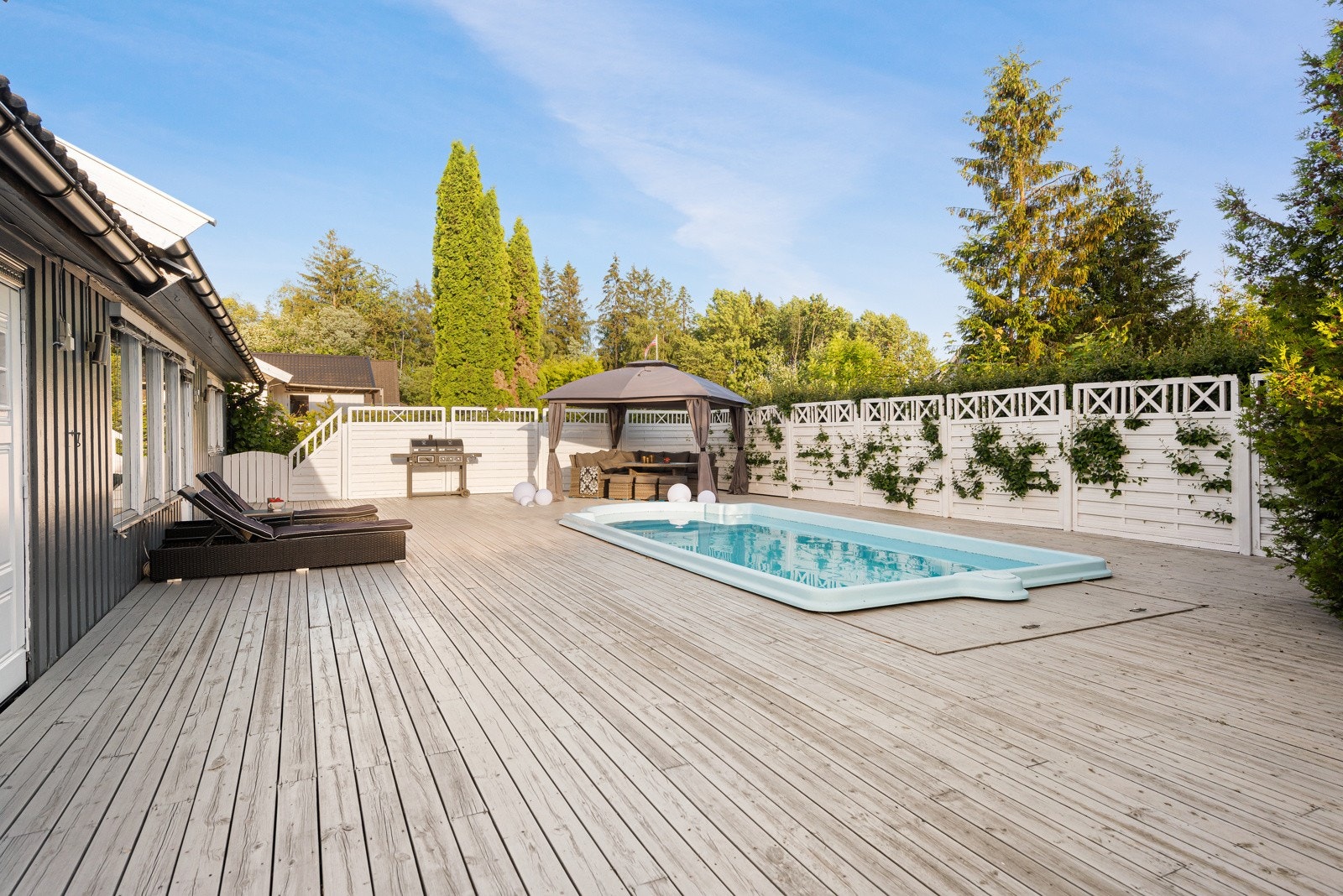 Hele området er inngjerdet av høye levegger som gjør det svært privat og i hver ende er det porter ut til hagen. Galleribilde