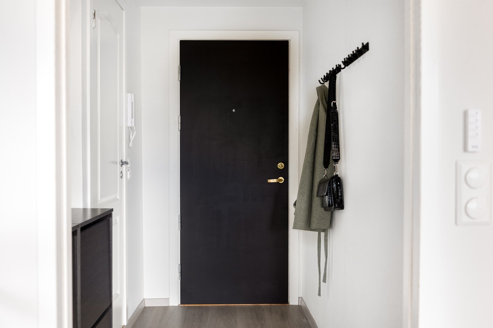 Åpen og lys entré med knagger for yttertøy og skoskap Galleribilde