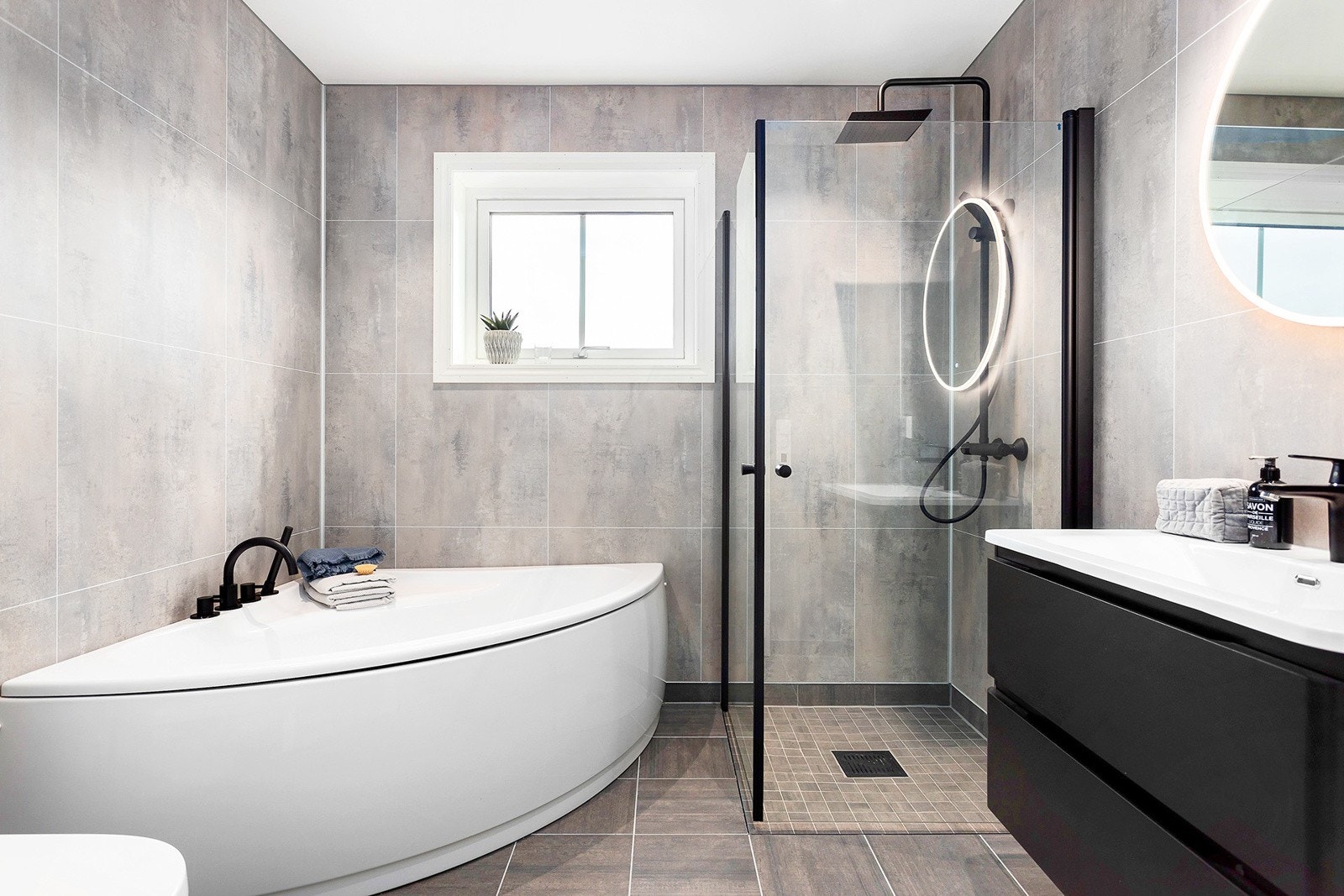 Boligens andre bad har badekar, dusjhjørne med innfellbare glassdører og innredning. Galleribilde