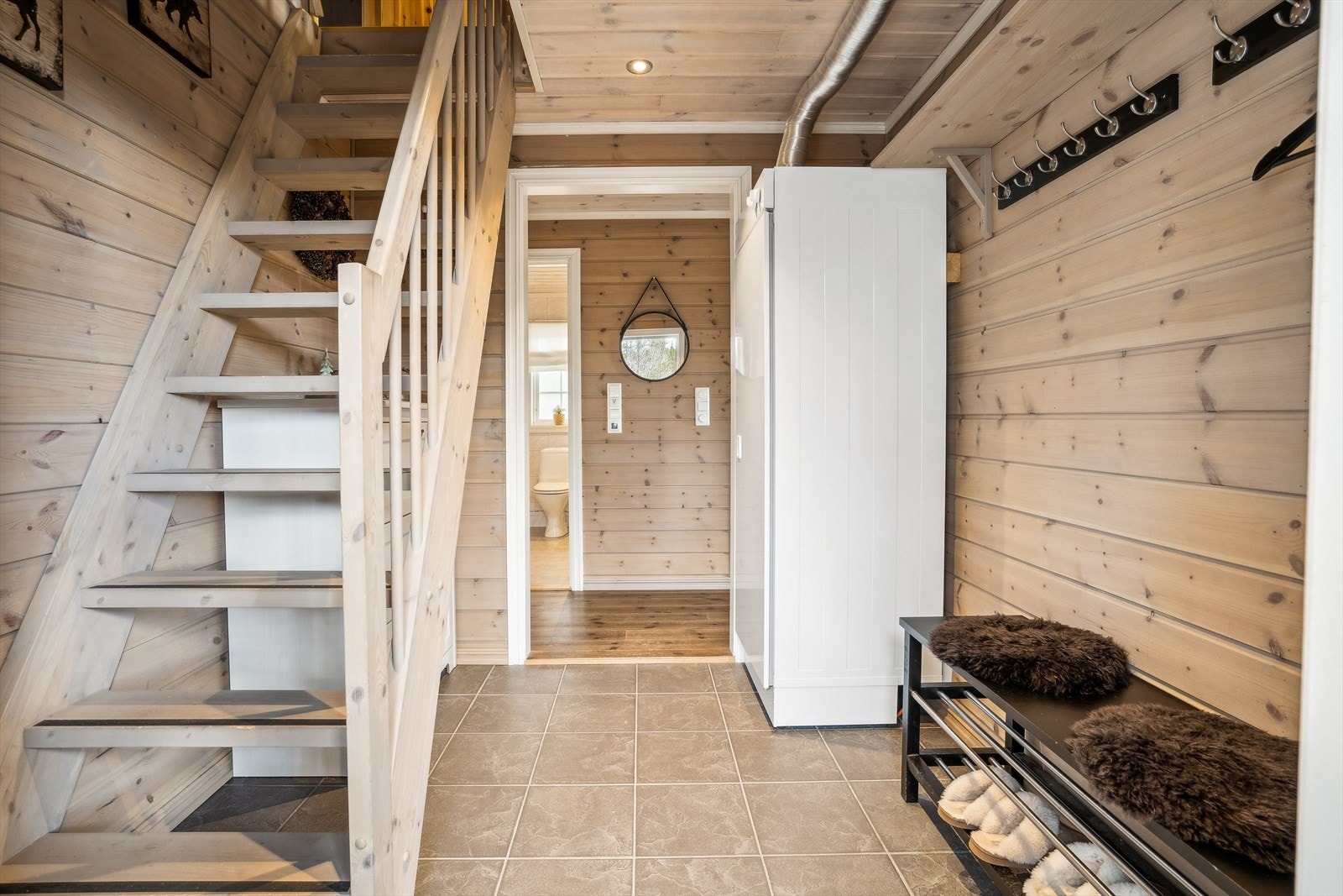 Entréen har flislagte gulv med lun gulvvarme. Her er det plass til å henge fra seg yttertøyet og det er montert tørkeskap i entréen. Galleribilde