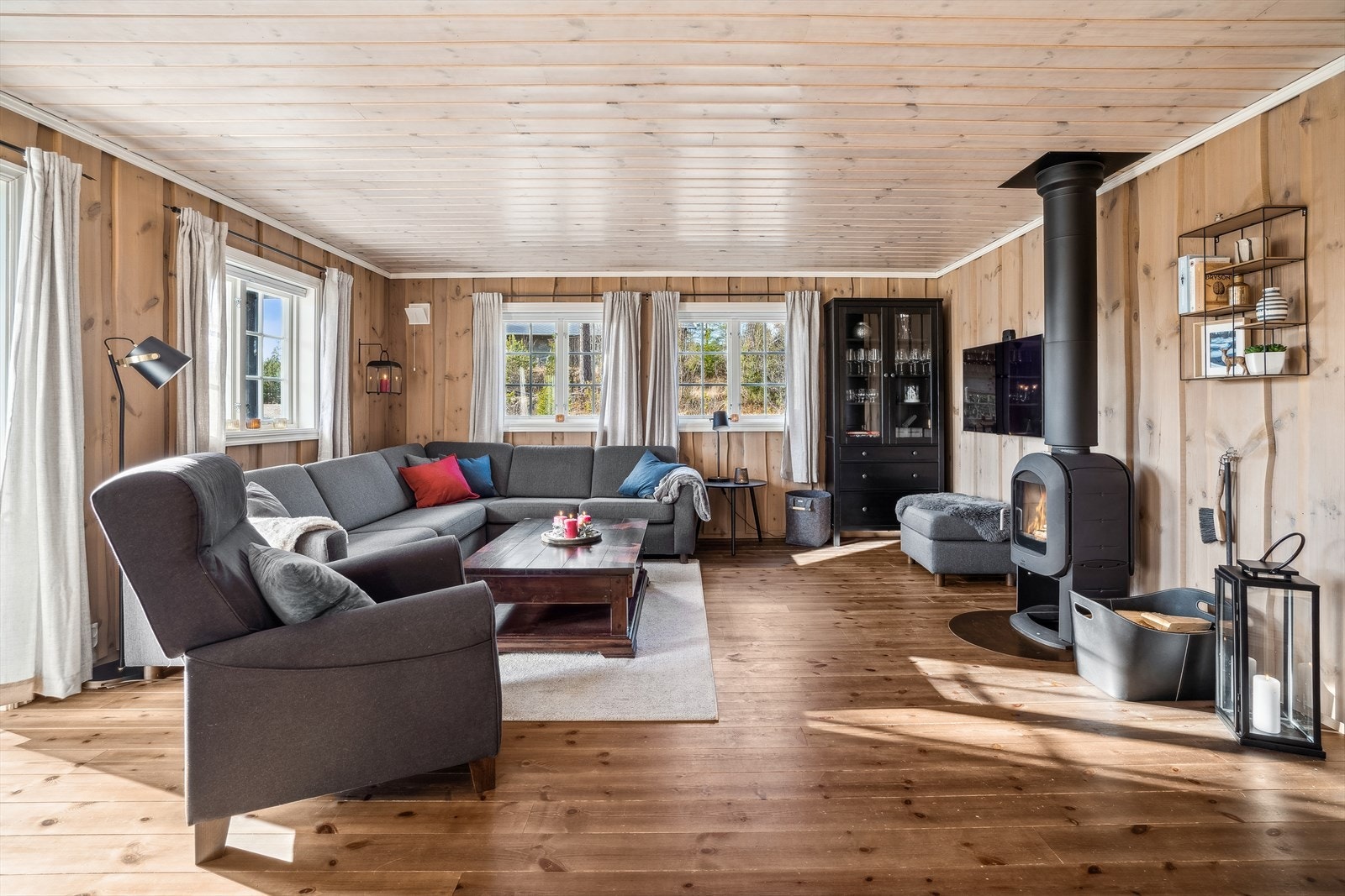 Stuen har lakkerte gulvbord og beiset trepanel på vegger og i himling. Peisovnen i stuen sørger for god varme. Galleribilde