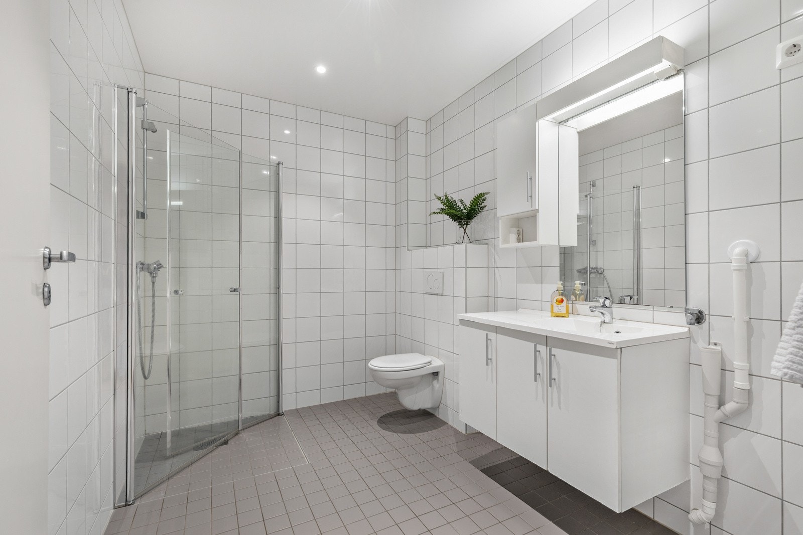 Flislagt bad med opplegg for vaskemaskin. Galleribilde