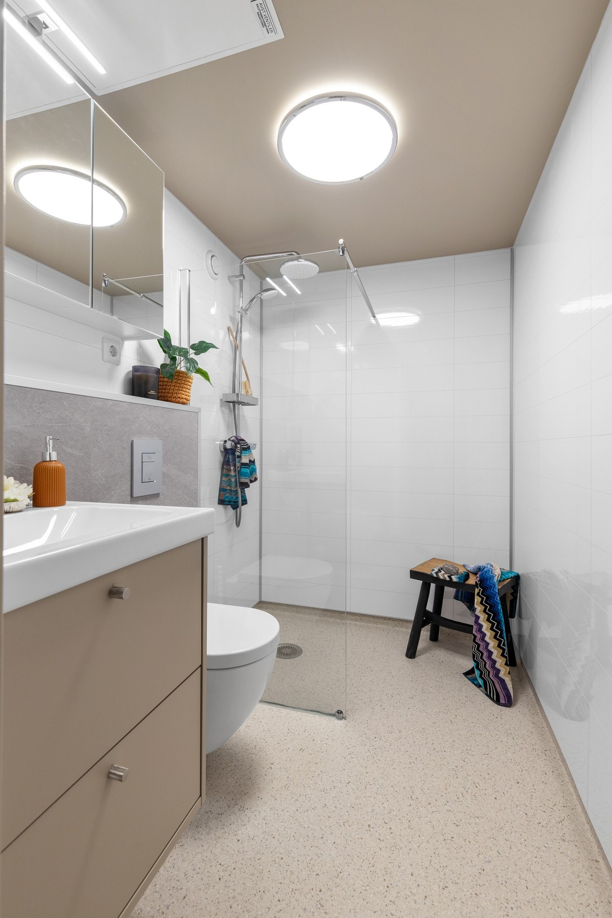 Videre er det et vegghengt toalett og dusjvegg, togreps blandebatteri, regndusj og hånddusj Galleribilde