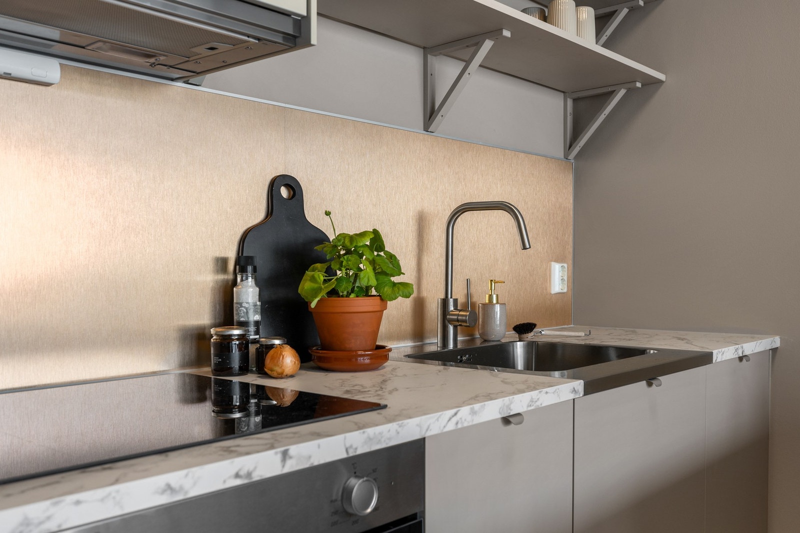 Komfyrvakt er plassert over platetopp, og det er montert en praktisk kjøkkenøy med barløsning Galleribilde