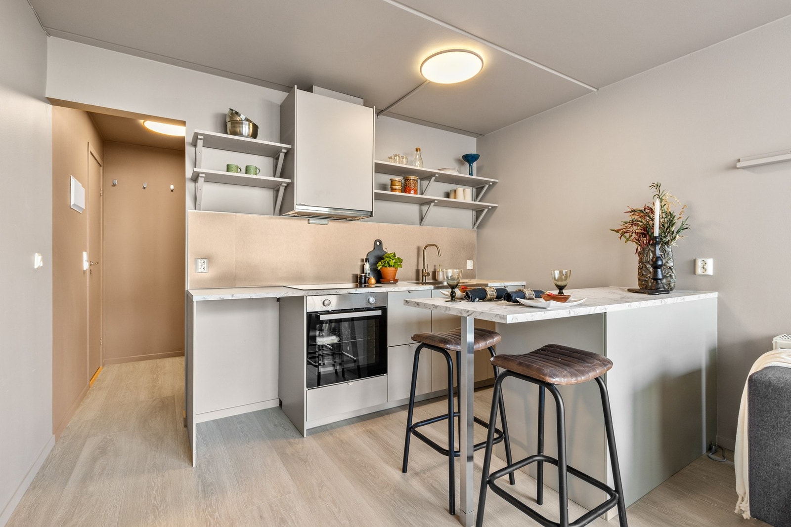 Pen kjøkkeninnredning fra 2025 med slette fronter og laminert benkeplate med nedsenket oppvaskkum i metall med ett-greps blandebatteri Galleribilde