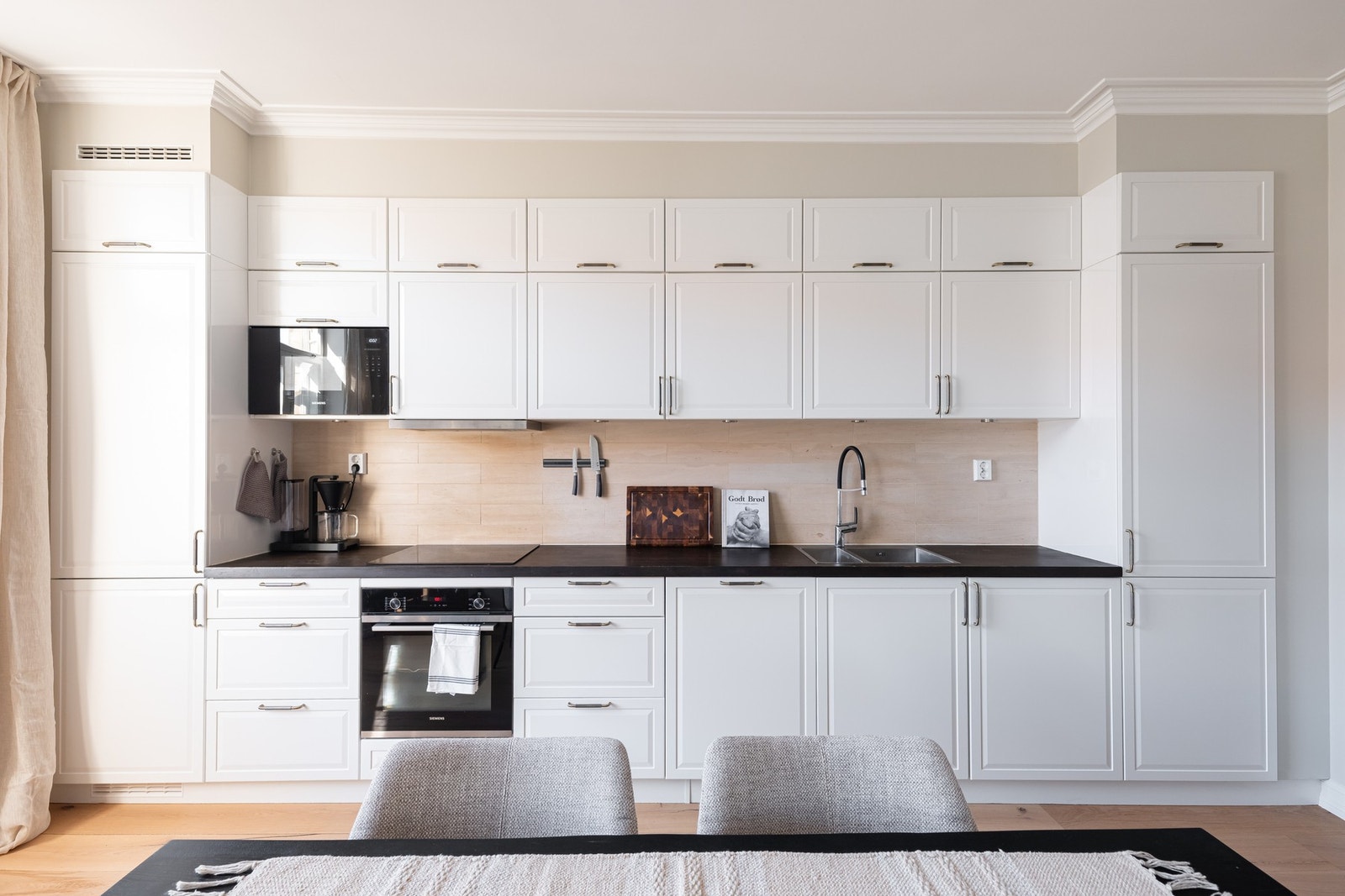 Lys, profilert innredning med benkeplate av treverk og nedfelt oppvaskkum med ett-greps armatur. Galleribilde