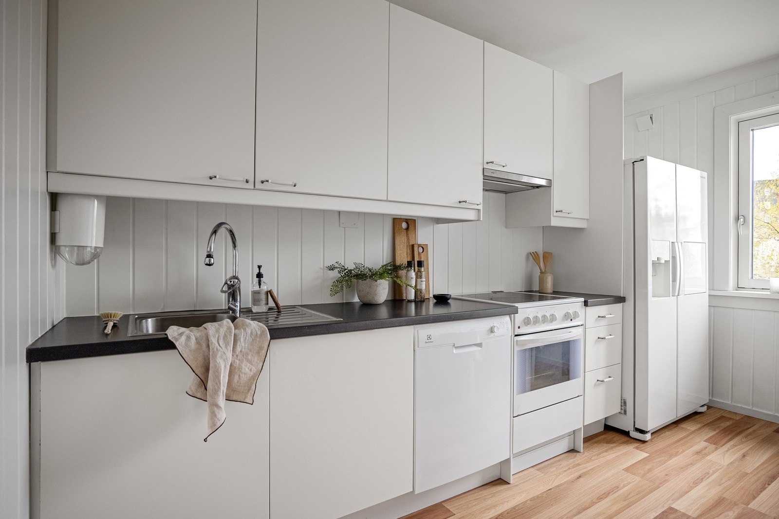 Moderne kjøkkeninnredning med hvite glatte fronter. Opplegg til oppvaskmaskin. Galleribilde