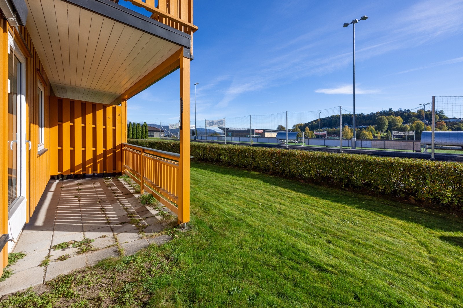 Usjenert platting på utsiden av leiligheten, med fin utsikt mot Ulefoss kunstgressbane Galleribilde