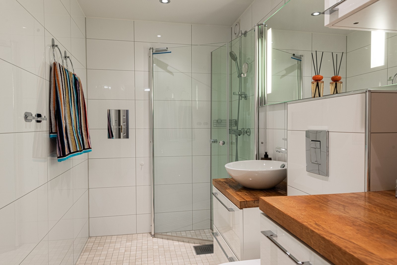 Delikat bad med downlights i himlingen som gir jevn og behagelig belysning. Speil med integrert lys tilfører både funksjon og stemning Galleribilde