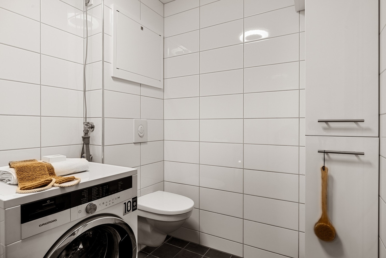 Badet er utstyrt med veggmontert toalett, moderne dusjløsning med hjørnevegg, nedfelt servant. Galleribilde