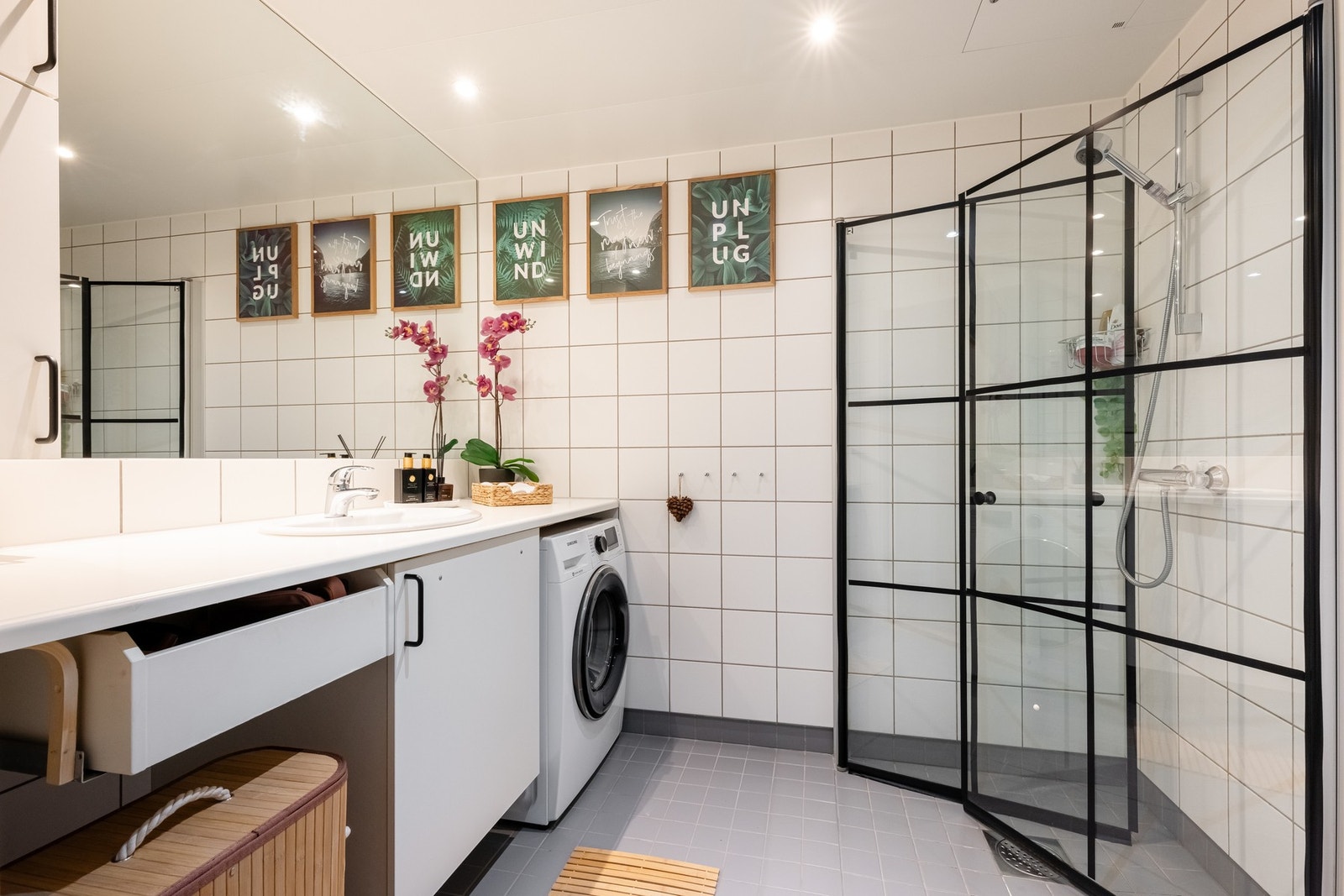 Lyst, flislagt baderom med varme i gulv og downlights i himling. Badet har opplegg for vaskemaskin og plass til tørketrommel under benk. Galleribilde