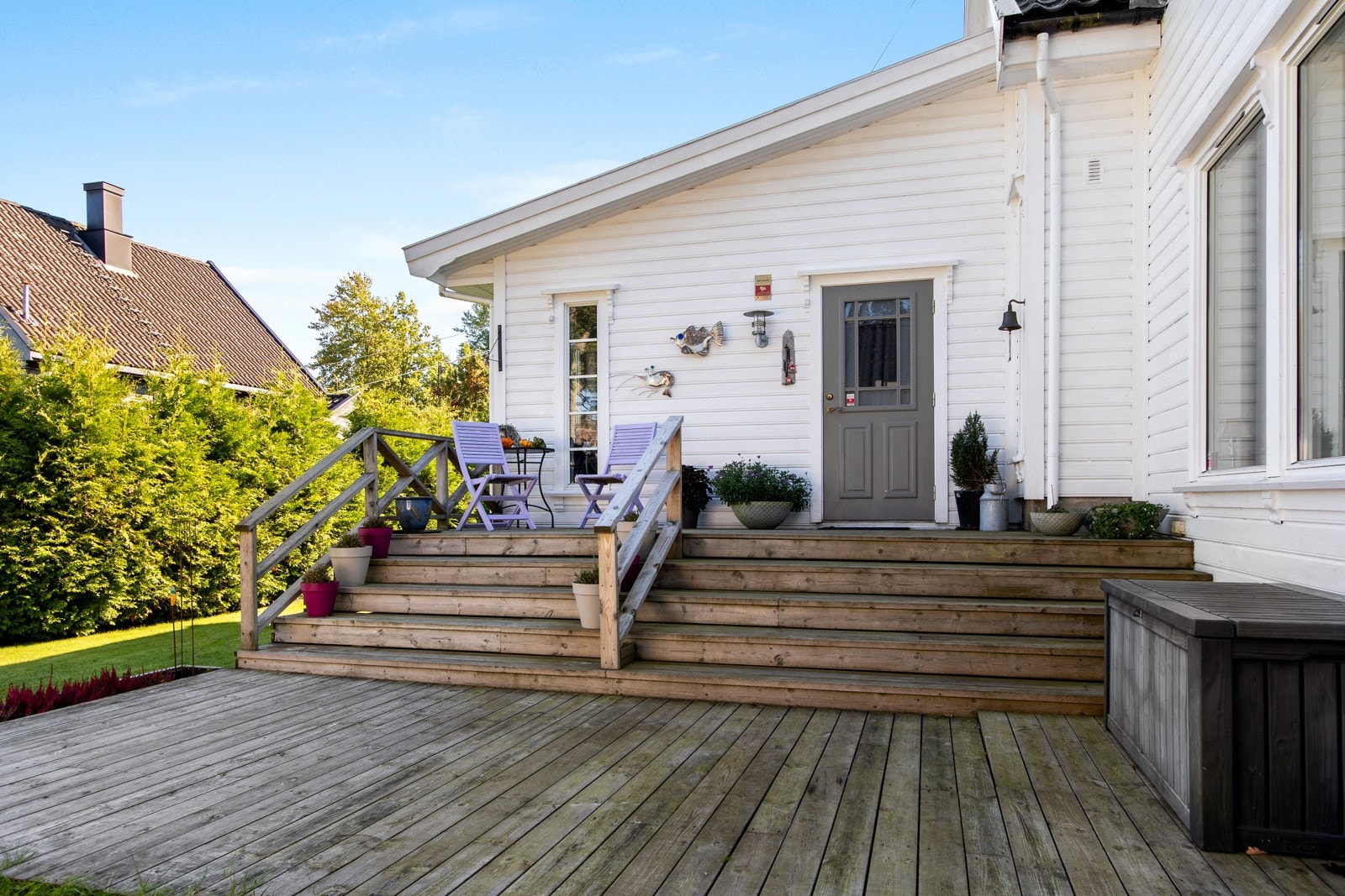 En overbygd inngangsdør er en del av verandaen, med glassfelt og tilhørende belysning. Galleribilde