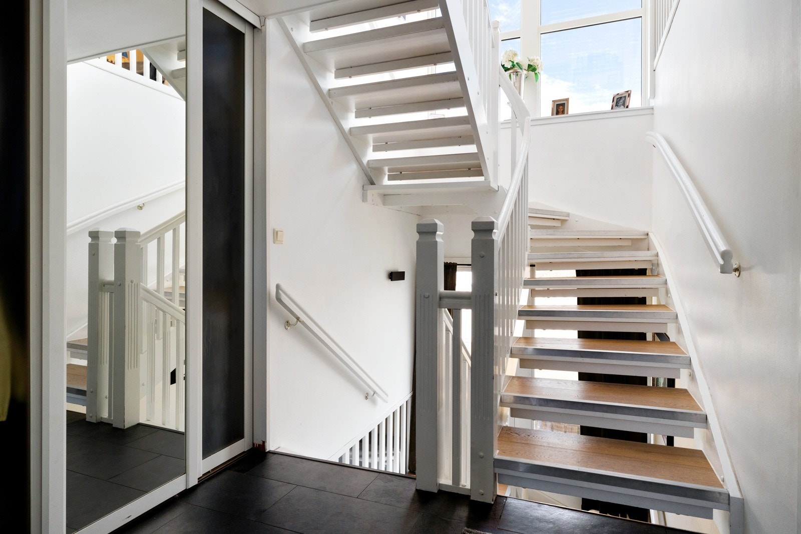 Fra gangen er det trapp opp til andre etasje og ned til underetasjen. De store vindusflatene i huset slipper inn rikelig med naturlig lys, noe som skaper et lyst og innbydende førsteinntrykk. Galleribilde