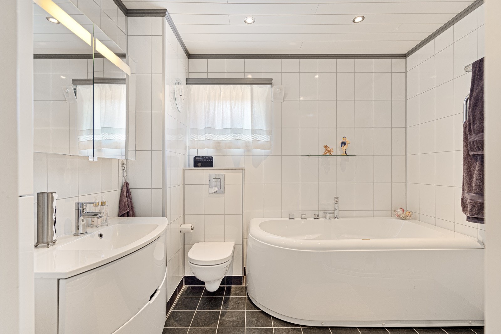 Badet er flislagt på guvl og vegger Galleribilde