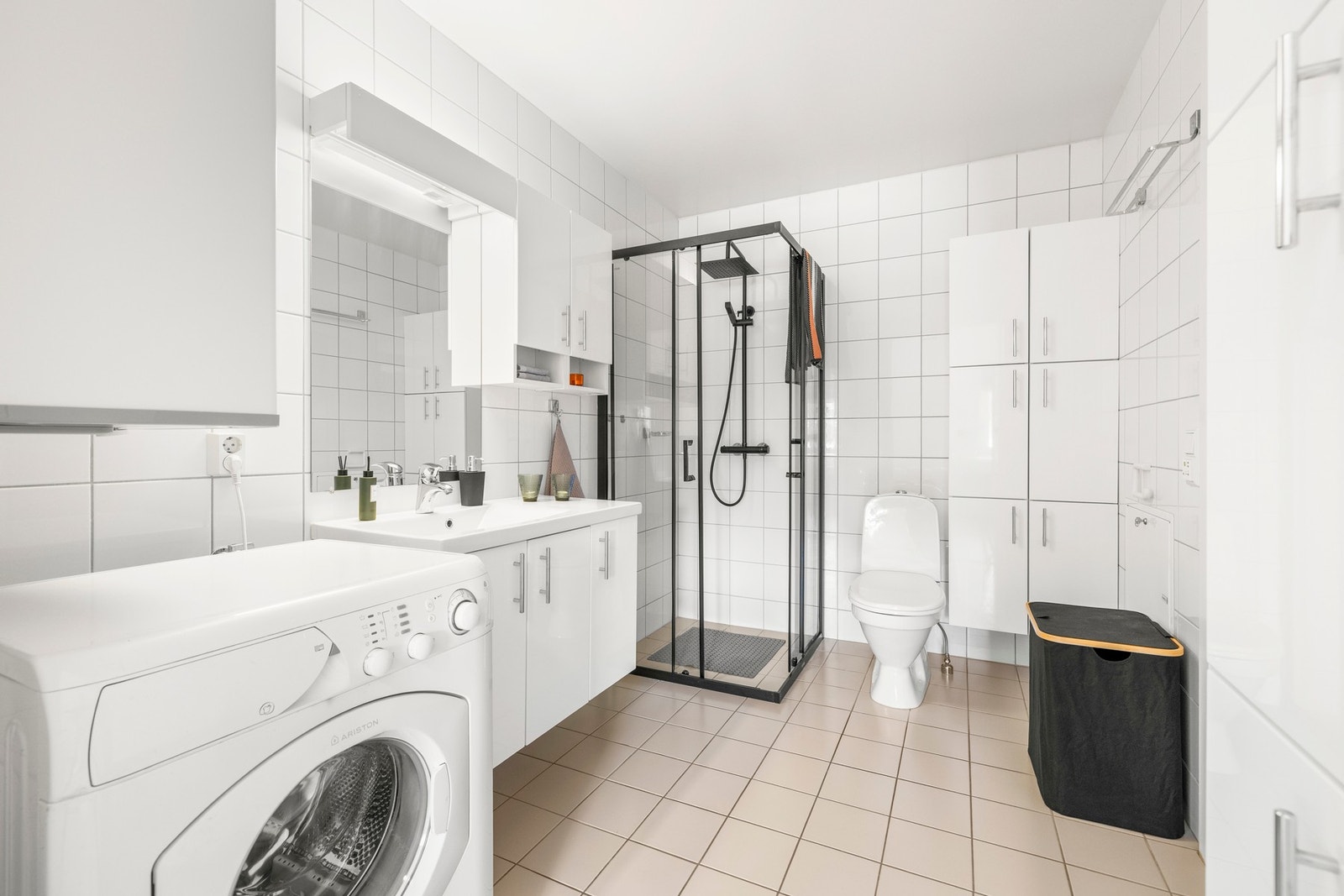 Pent flislagt baderom med gulvvarme, opplegg for vaskemaskin og god oppbevaringsplass. Galleribilde